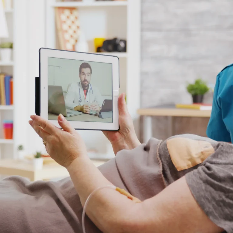 old-disabled-woman-lying-hospital-bed-having-online-video-call-with-doctor-nurse-is-her